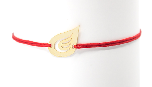 bransoletka w postaci sznureczka ze srebrnym, pozłoconym elementem, który jest odwzorowaniem logo firmy PGNIG